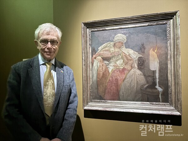 알폰스 무하의 손자인 존 무하 (무하 트러스트 대표). 옆의 작품은 알폰스 무하의 1933년 작품으로 체코의 국보인  '촛불을 응시하는 여인' (사진 함혜리)