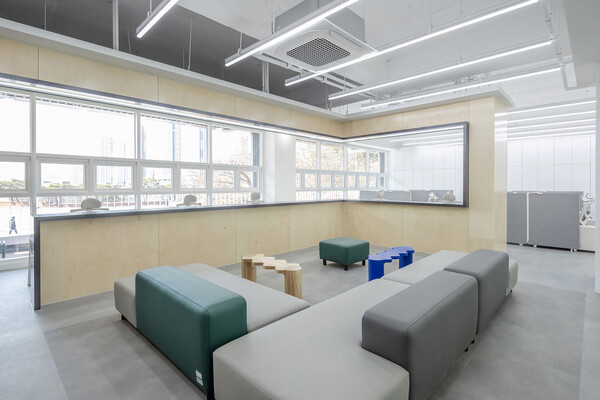 Bar 라운지. 우드톤의 바 테이블을 설치하여 혼자 쉴 수 있는 공간으로 구성했다. 격자의 우드 프레임을 창 주위를감싸 편안하면서 따듯한 분위기를 연출하고자 하였고, 다이크로익 필름을 부착하여 다채로운 빛이 들어올 수 있도록했다. (사진 tqtq studio)