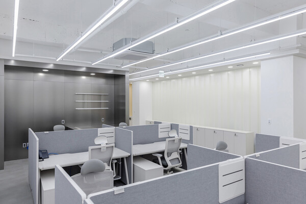 학사지원팀의 업무공간은 밝은 분위기를 연출하기 위해 화이트톤의 가구들과 유글라스를 사용하여 활력을 불어넣고자 했다. 또한 벽을 대신하여 긴 장을 설치하여 업무 시필요한 서류 및 자료를 수납할 수있도록 했다. (사진 tqtq studio)